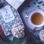 Livro “Orgulho e Preconceito” ao lado de uma xícara de chá e flores sobre uma superfície clara