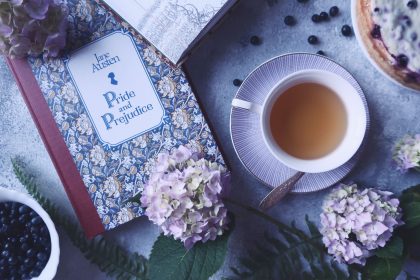 Livro “Orgulho e Preconceito” ao lado de uma xícara de chá e flores sobre uma superfície clara