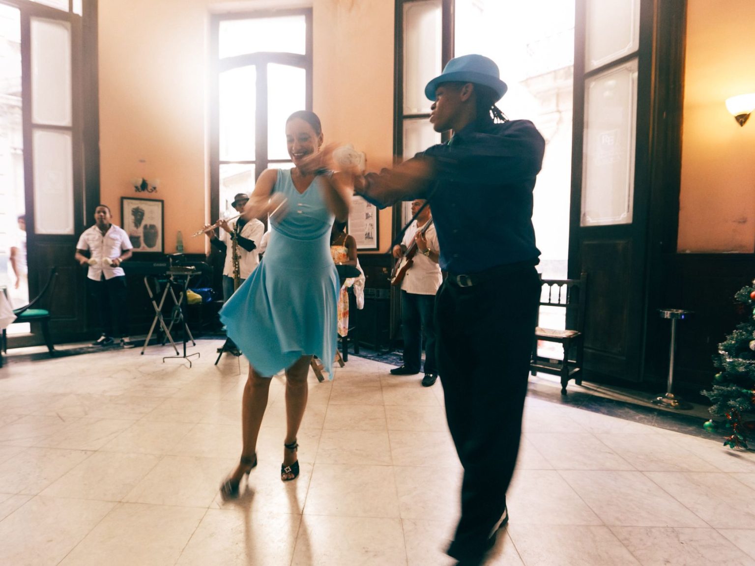 Casal dança em um salão elegante, em uma cena que remete aos musicais clássicos.