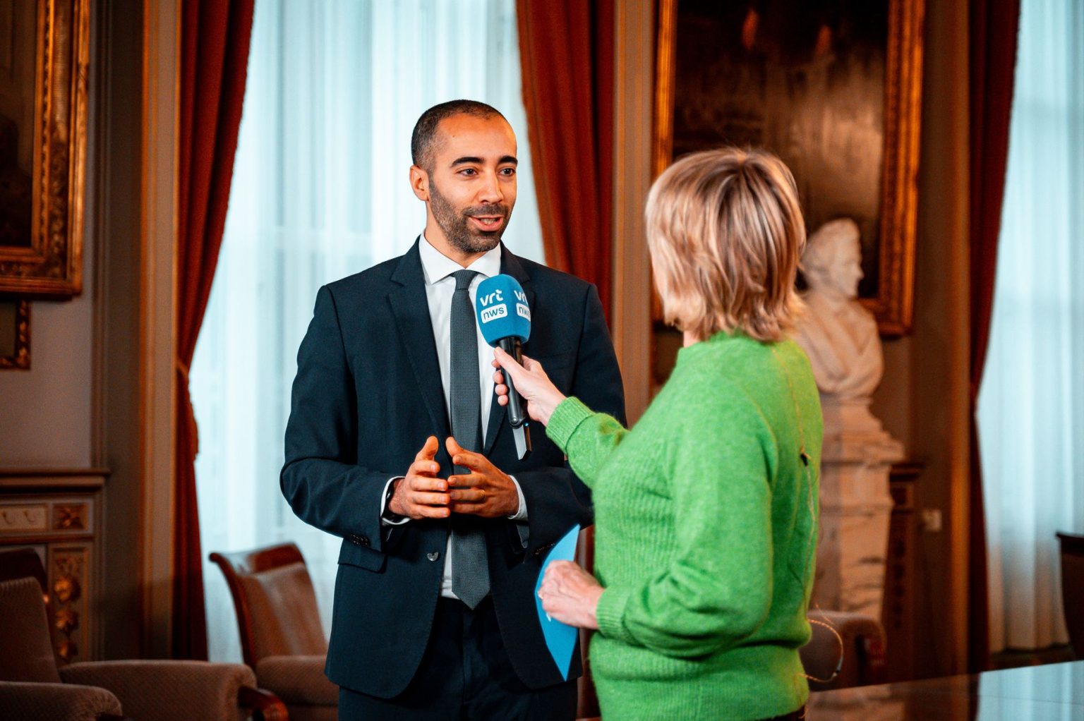 Jornalista entrevista um profissional durante um evento do setor de mídia.