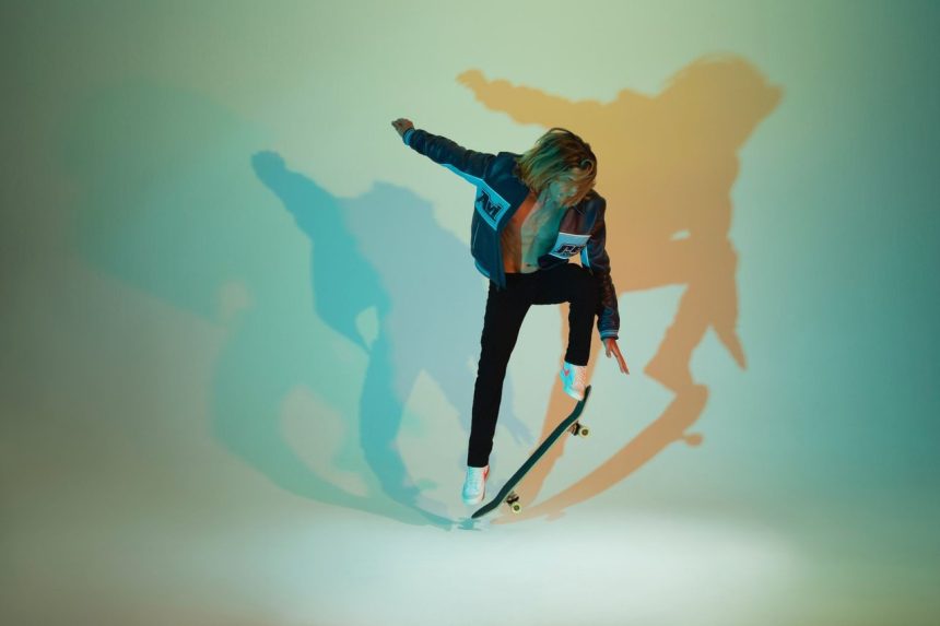 Skateboarder realiza uma manobra em ambiente com iluminação colorida e sombras dinâmicas.